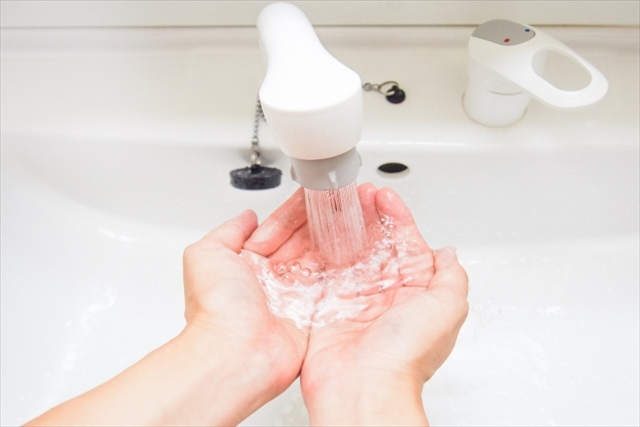名古屋市緑区のリフォームは、洗面台のお悩みもお任せの【近所の大工さん】で！。洗面台の蛇口から水を出して手を洗っている画像